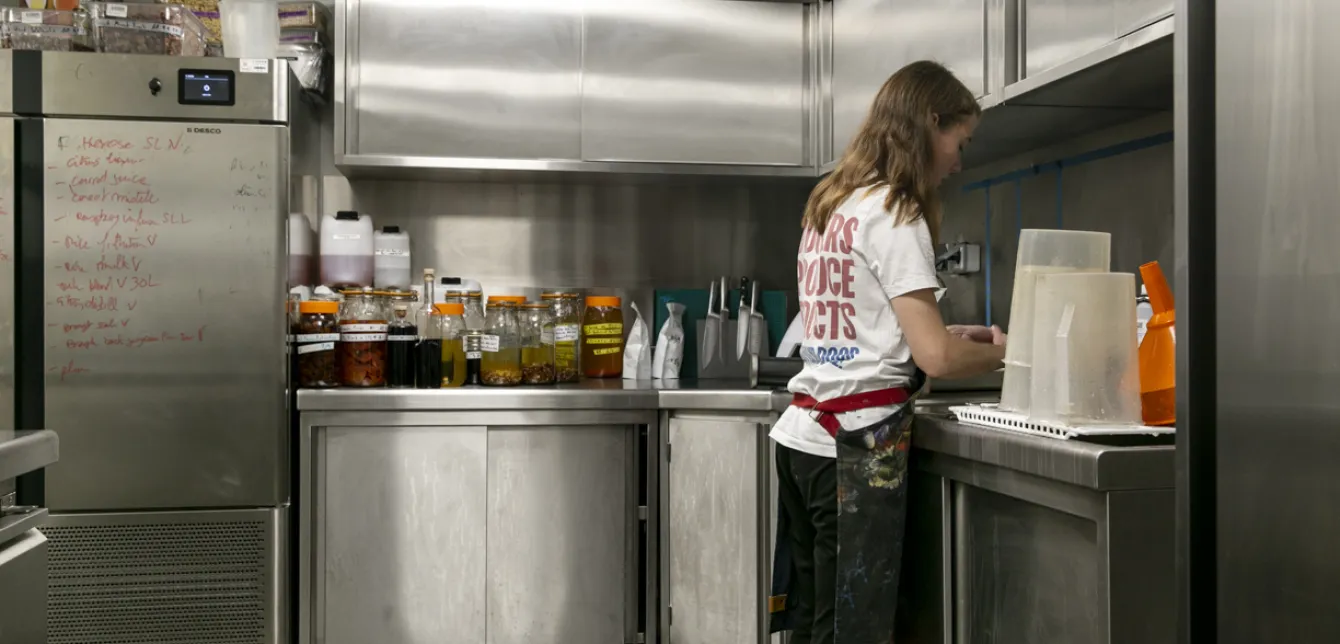Photographie d'une femme de dos dans une cuisine